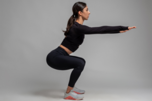 Proper squat form preventing knee pain in Markham, showing a woman performing a squat exercise with correct posture and alignment.